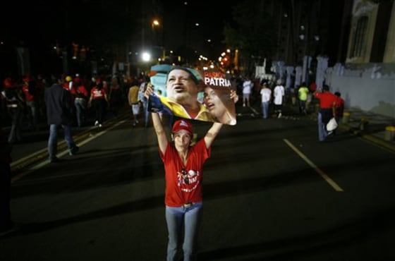 A supporter of Venezuela's President Hugo Chavez, holds up a poster of him as she is leaviing after learn the results of congressional elections, outside of Presidential Palace in Caracas, Venezuela, on Monday. President Hugo Chavez held on to a congressional majority in elections Sunday, but his opponents made gains that could help them challenge his grip on power.